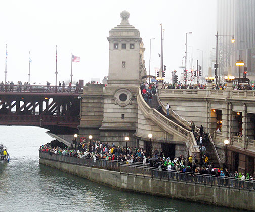 Crowds gather along the Michigan Avenue bridge, Chicago, for dyeing of the Chicago River Green, March 13, 2010