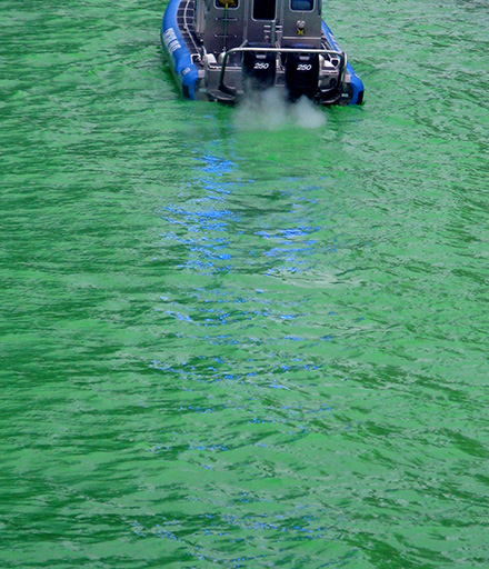 Police boat on a Chicago river dyed green for St. Patrick's day, March 13, 2010