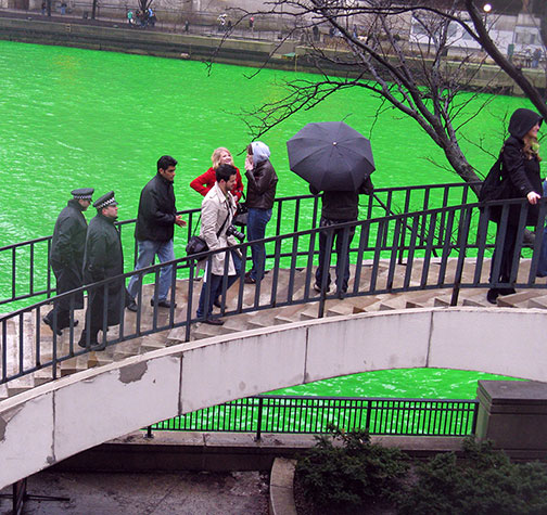 Spectators on Pioneer Plaza stair as Chicago River is dyed green for St. Patrick's day, March 13, 2010